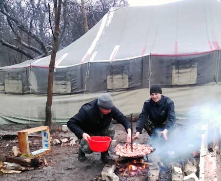Палатки установили прямо на сырой земле, а еду готовят на костре.